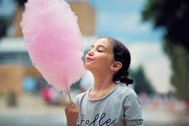 Someone holding a freshly made cotton candy cone